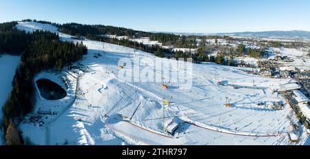 Skipiste, Sessellifte, Skifahrer und Snowboarder im Winter im Skigebiet Bialka Tatrzanska in Polen auf dem Berg Kotelnica. Luftpanorama im niedrigen Dezember Stockfoto