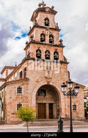 Die Pfarrkirche Santa María de la Asunción. Der dreistöckige, gestufte Glockenturm nimmt an Breite ab und wird von einem dreieckigen Giebel gekrönt. Cangas de ON Stockfoto