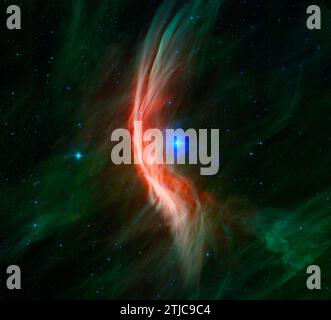 Der Riesenstern Zeta Ophiuchi und die umliegenden Staubwolken in diesem Infrarotbild des Spitzer Space Telescope der NASA. Sternwinde, die von diesem sich schnell bewegenden Stern ausströmen, wackeln sich im Staub, während er sich nähert, und erzeugen einen Bogenschock, der als leuchtende Gossamer-Fäden betrachtet wird, die für diesen Stern nur im Infrarotlicht zu sehen sind. Zeta Ophiuchi ist ein junger, großer und heißer Stern, der etwa 370 Lichtjahre entfernt liegt. Sie schwingt unsere eigene Sonne in vielerlei Hinsicht - sie ist etwa sechsmal heißer, achtmal breiter, 20 mal massereicher und etwa 80.000 mal so hell. Ein optimiertes NASA-Bild / Kredit: NASA Stockfoto