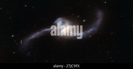 Das Bild des NASA/ESA Hubble Weltraumteleskops zeigt, was passiert, wenn zwei Galaxien zusammenfließen. Der verdrehte kosmische Knoten, der hier zu sehen ist, ist NGC 2623 Ñ oder Arp 243 Ñ und befindet sich etwa 250 Millionen Lichtjahre entfernt im Sternbild Krebs. NGC 2623 erhielt seine ungewöhnliche und unverwechselbare Form durch eine größere Kollision und anschließende Verschmelzung zweier getrennter Galaxien. Diese heftige Begegnung führte dazu, dass Gaswolken innerhalb der beiden Galaxien komprimiert und aufgerührt wurden, was wiederum einen scharfen Anstieg der Sternentstehung auslöste. Eine optimierte Version eines Originalbildes der NASA / Credit: NASA Stockfoto
