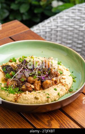 Hummus mit warmer Aubergine in süßer Chilisauce. Gesundes veganes Essen, israelische Küche. Restaurant-Menü-Konzept. Kopierbereich. Stockfoto