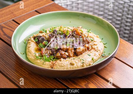 Hummus mit warmer Aubergine in süßer Chilisauce. Gesundes veganes Essen, israelische Küche. Stockfoto