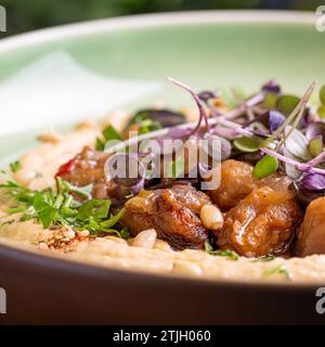 Hummus mit warmer Aubergine in süßer Chilisauce. Gesundes veganes Essen, israelische Küche. Stockfoto