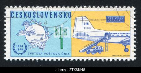 TSCHECHOSLOWAKEI - CA. 1974: Stempel gedruckt von der Tschechoslowakei, zeigt das Uniform Postal Union Emblem und das Postflugzeug der Tschechoslowakei, ca. 1974 Stockfoto