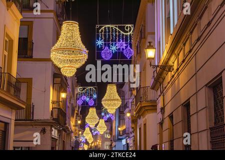 Weihnachtsbeleuchtung Dekoration in der Sierpes Straße in Form eines goldenen Empire Stil Kristall Kandelabers, im Zentrum von Sevilla, Andalusien, Spai Stockfoto