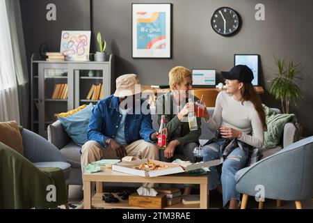 Fröhliche junge Freunde reden und trinken Soda Stockfoto