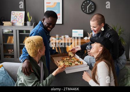 Stilvolle junge Leute, die sich unterhalten und Pizza essen Stockfoto