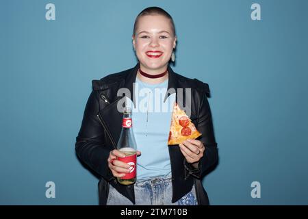 Glam Rock Junge Frau mit Pizza und Limonade Stockfoto