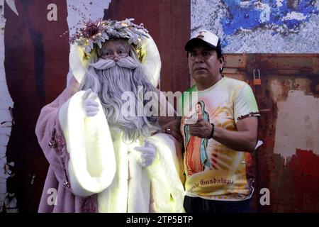 Mexiko-Stadt, Mexiko. Dezember 2023. 20. Dezember 2023, Mexiko-Stadt: Der auf Statuismus spezialisierte szenische Künstler Jose Miguel Moctezuma, der als der beleuchtete Weihnachtsmann charakterisiert ist, verteilt Umarmungen und macht ein Erinnerungsfoto mit Nutzern des Metro Collective Transportation Systems in Mexiko-Stadt. Am 20. Dezember 2023 in Mexiko-Stadt, Mexiko (Foto: Luis Barron/Eyepix Group/SIPA USA). Quelle: SIPA USA/Alamy Live News Stockfoto