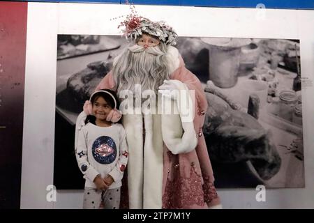 Mexiko-Stadt, Mexiko. Dezember 2023. 20. Dezember 2023, Mexiko-Stadt: Der auf Statuismus spezialisierte szenische Künstler Jose Miguel Moctezuma, der als der beleuchtete Weihnachtsmann charakterisiert ist, verteilt Umarmungen und macht ein Erinnerungsfoto mit Nutzern des Metro Collective Transportation Systems in Mexiko-Stadt. Am 20. Dezember 2023 in Mexiko-Stadt, Mexiko (Foto: Luis Barron/Eyepix Group/SIPA USA). Quelle: SIPA USA/Alamy Live News Stockfoto