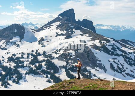 Wanderer feiert den Aufstieg mit Black Tusk im Hintergrund. Stockfoto