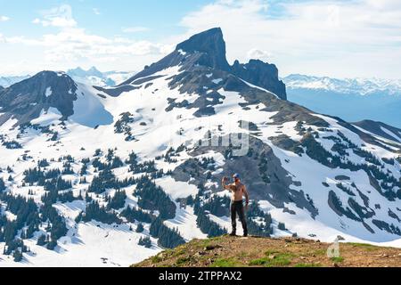 Wanderer feiert den Aufstieg mit Black Tusk im Hintergrund. Stockfoto