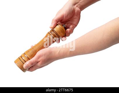 Hölzerne Pfeffermühle in der Hand der Männer isoliert auf weißem Hintergrund. Stockfoto
