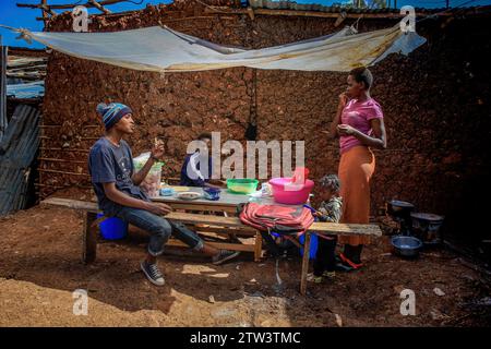 Nairobi, Kenia. Dezember 2023. Die Einheimischen nehmen ihr Frühstück in einem offenen Mini-Restaurant in Kibera Slum, Nairobi, ein. Ein Blick auf das tägliche Leben in Kibera, das derzeit größte Slum Africaís, und die alltäglichen Geschäftsaktivitäten der Anwohner. Quelle: SOPA Images Limited/Alamy Live News Stockfoto