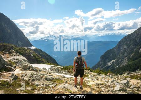 Alleinwanderer genießen die weite Aussicht auf das Tal vom Wedgemount Lake Trail. Stockfoto