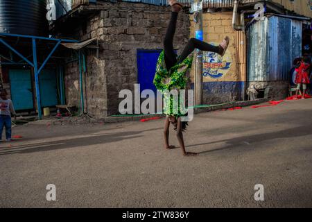 Nairobi, Kenia. Dezember 2023. Ein junges Mädchen, das in Kibera Slum, Nairobi, auf der Straße einen Somersault aufführt. Ein Blick auf den Alltag in Kibera, dem derzeit größten Slum Afrikas, und die täglichen Geschäftsaktivitäten der Einwohner. (Kreditbild: © Donwilson Odhiambo/ZUMA Press Wire) NUR REDAKTIONELLE VERWENDUNG! Nicht für kommerzielle ZWECKE! Stockfoto