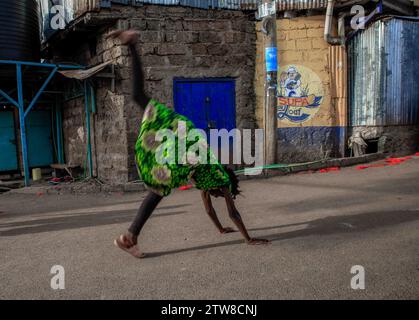 Nairobi, Kenia. Dezember 2023. Ein junges Mädchen, das in Kibera Slum, Nairobi, auf der Straße einen Somersault aufführt. Ein Blick auf den Alltag in Kibera, dem derzeit größten Slum Afrikas, und die täglichen Geschäftsaktivitäten der Einwohner. (Kreditbild: © Donwilson Odhiambo/ZUMA Press Wire) NUR REDAKTIONELLE VERWENDUNG! Nicht für kommerzielle ZWECKE! Stockfoto