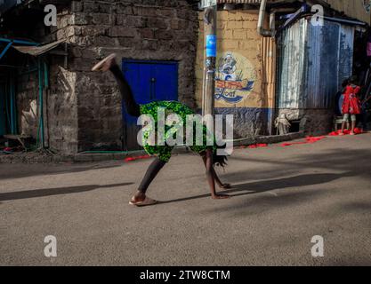 Nairobi, Kenia. Dezember 2023. Ein junges Mädchen, das in Kibera Slum, Nairobi, auf der Straße einen Somersault aufführt. Ein Blick auf den Alltag in Kibera, dem derzeit größten Slum Afrikas, und die täglichen Geschäftsaktivitäten der Einwohner. (Kreditbild: © Donwilson Odhiambo/ZUMA Press Wire) NUR REDAKTIONELLE VERWENDUNG! Nicht für kommerzielle ZWECKE! Stockfoto