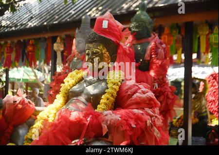 Statue von Phra Sangkajai oder Fat Happy Buddha mit einem roten Tuch gebunden, um im Wat Saeng Kaeo Phothiyan Tempel eine Hommage zu erweisen. Gelegen in Chiang Rai Stadt. Stockfoto