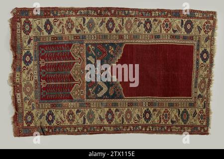 Gebetsteppich mit Bovendwarspaneel, Ladik, 1800 - 1900 Gebetsteppich mit Oberwars-Platte, Ladik. Mittelfeld: Glatter roter Mihrab mit einer gestuften Treppe in der Mitte. Blaue Schaukel mit bunten Sternblumen und gezahnten Lanzettenblättern auf einem horizontalen S-Rang. Eine Neigungskante ist rosa mit weißem „Omega-Alijn“, radikal in einer roten oberen Platte, auf der lange Tulpen stehen, abwechselnd blau (3) und weiß (2). Kanten: Vierfach. Der Hauptrand ist in zartem Gelb mit diamantförmigen, bedruckten Rosettenblüten, abwechselnd mit schrägen, gestreiften Tulpen. Ein innerer Zoom ist schwarz mit mehrfarbigen Rosetten. Die Außenstehenden Stockfoto