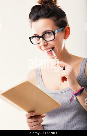 Tief besinnt sie ihr Notizbuch und ihren Stift, ein Porträt intellektueller Auseinandersetzung Stockfoto