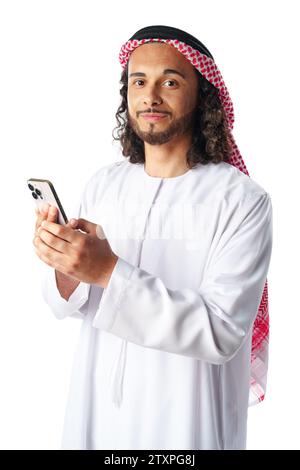Junger arabischer Mann in traditioneller Kleidung, der ein Smartphone auf weißem Hintergrund benutzt Stockfoto