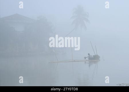 Ein Arbeiter sammelt Plankton an einem nebeligen Morgen am MBB College Lake in Agartala. Tripura, Indien. Stockfoto