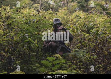 Sukabumi, Indonesien. Dezember 2023. Reagan Gessler, ein Anführer des 1. Bataillons, 7. Marineregiment, der Marine Rotationstruppe Südostasien angehört, Handsignale an indonesische Marines mit dem 4. Marineinfanterie-Bataillon, Pasmar 1, auf einer Sicherheitspatrouille während der Keris Marine Übung 2023 als Teil der MRF-SEA im Piabung Training Area in Sukabumi, West-Java, Indonesien, Dezember. 6, 2023. MRF-SEA ist ein pazifisches Einsatzmodell der Marine Corps Forces, das den Austausch mit Fachexperten umfasst, Sicherheitsziele mit Alliierten und Partnern fördert und Positionen einbezieht Stockfoto