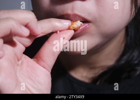 Frau isst gebratenes Huhn, Street Food in thailand Stockfoto