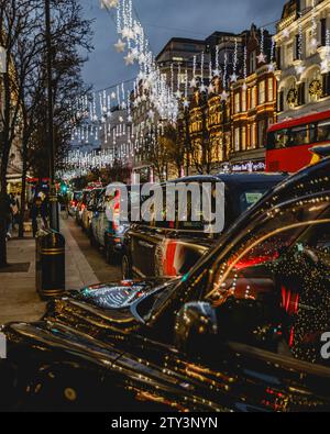 Während der Festtage stehen mehrere Taxis für Fahrten vor dem Selfridge's in London an. Stockfoto