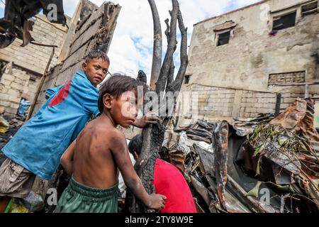 Manila, Philippinen. Dezember 2023. Kinder werden gesehen, als sie am 20. Dezember 2023 nach einem Brand in einem Slumgebiet in Manila, den Philippinen, in die verkohlten Häuser zurückkehren. Quelle: Rouelle Umali/Xinhua/Alamy Live News Stockfoto