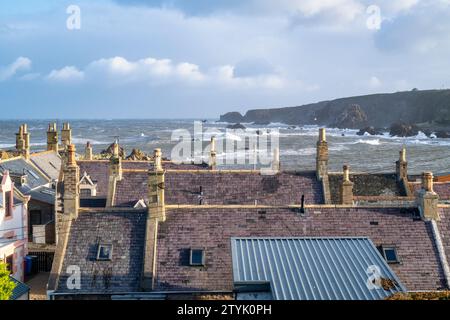 Hausdächer in Findochty Bay mit einem turbulenten Meer. Findochty, Morayshire, Schottland Stockfoto