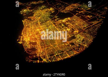 Dubai, aus der Luft, Lichter aus der Stadt leuchten hell in die dunkle Nacht. Stockfoto