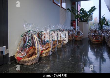 Auf dem Boden befinden sich viele Geschenkkörbe gefüllt mit Wurst und Schinken Stockfoto
