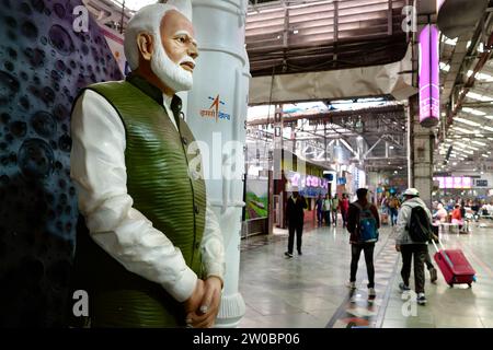 Eine Statue des indischen Premierministers Narendra Modi am Chhatrapati Shivaji Maharaj Terminus in Mumbai, Indien, mit Bahnpassagieren im Hintergrund Stockfoto