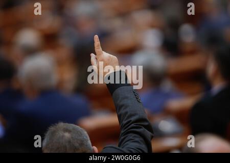 Bukarest, Rumänien - 20. Dezember 2023: Ein parlamentsabgeordneter gibt seinen Kollegen Gesten, wie man über Gesetzesentwürfe abstimmt. Stockfoto