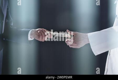 Mann, der einen Stapel von Hundert-Dollar-Scheinen anbietet. Hände nah dran. Stockfoto