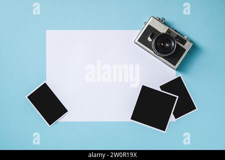 Vintage-Fotokamera und leere Bilderrahmen auf blauem Hintergrund. Fahrmoment-Konzept Stockfoto
