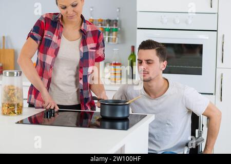 Behinderte im Rollstuhl zusammen - Mann paar kochen Stockfoto