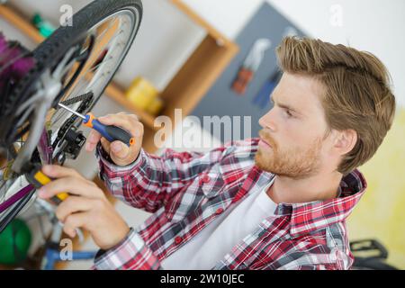 stilvolle Fahrradmechaniker seiner professionellen Arbeit in Werkstatt Stockfoto