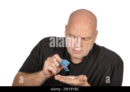 Älterer kaukasischer Mann, der tägliche Medikamente einnimmt - Gesundheitskonzept auf weißem Hintergrund mit Copy Space Stockfoto