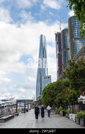 Menschen laufen entlang der Uferpromenade von Darling Harbour in Barangaroo in Richtung Crown Sydney Tower Stockfoto