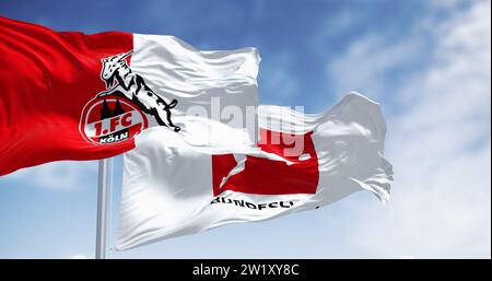 Köln, DE, 10. Oktober 2023: FC Köln-Flagge winkt mit Bundesliga-Flagge an einem klaren Tag. Professioneller deutscher Fußballverein. Illustratives Editorial 3d il Stockfoto