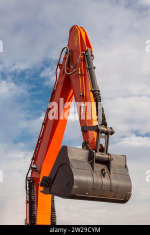 Erhobene Hand eines Baggers mit einer Schaufel gegen den Himmel. Stockfoto