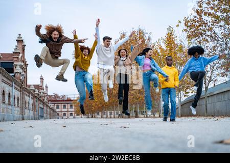 Aufgeregt und fröhlich, multiethnische Freunde, die draußen springen. Freundschaftskonzept. Stockfoto