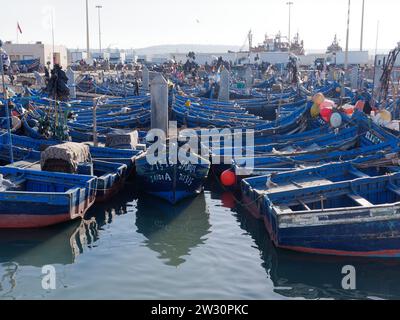 Blaue Fischerboote mit Schiff hinter dem Hafen in Essaouira, der „windigen Stadt“, Marokko. Dezember 2023 Stockfoto