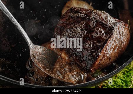 Gebratenes Rinderfilet mit Knoblauch und Rosmarin in einer Pfanne Stockfoto