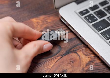 Abbildung eines usb-Kabels, das an einen Laptop-Anschluss angeschlossen ist. Das Konzept moderner ultraschneller Übertragungswege. Gemischte Medien Stockfoto