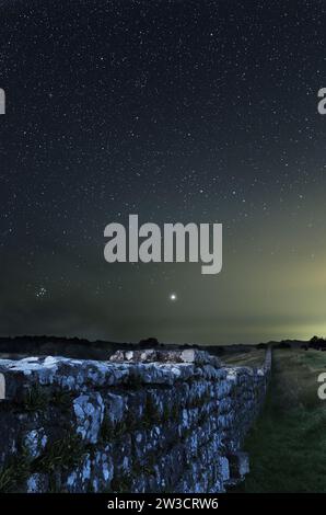 Hadrians Wall, östlich von Birdoswald Roman Fort, unter einem Sternenhimmel mit Jupiter und dem Pleiades Sternhaufen prominent, Northumberland, Großbritannien Stockfoto