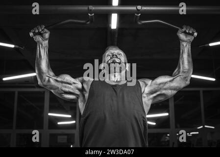 Bild eines leistungsstarken Athleten, der im Fitnessstudio einen Pull-Up macht. Rückpumpen. Fitness- und Bodybuilding-Konzept Stockfoto